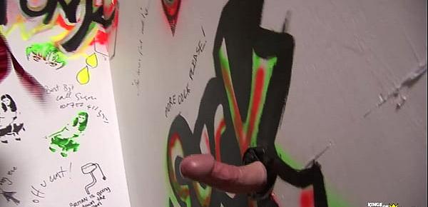 Busty brunette MILF blows a big cock trough the gloryhole after getting horny